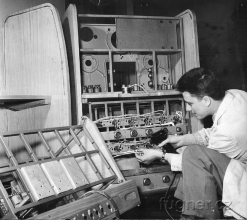 Obr. 1a. Technik Milan Fügner propojuje jednotlivé části skříně zesilovačů.  Foto ČTK.  Výstava Československo 1960 - Bruselský pavilon.